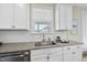Bright kitchen featuring a stainless steel sink, white cabinetry, and a granite countertop at 1212 Stonemill Falls Dr, Wake Forest, NC 27587