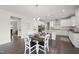 Open kitchen and dining area featuring white cabinetry, granite countertops, and stainless steel appliances at 1212 Stonemill Falls Dr, Wake Forest, NC 27587