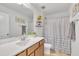 Bright bathroom featuring a large mirror, single vanity, and shower with decorative shower curtain at 123 Carbone Ln, Clayton, NC 27527