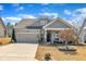 Charming single-Gathering home with a well-maintained lawn, attached garage, and inviting curb appeal on a sunny day at 123 Carbone Ln, Clayton, NC 27527