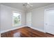 A bright bedroom features a window with a green yard view and beautiful hardwood floors at 1239 Brogden Rd, Smithfield, NC 27577