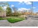 Spacious backyard with a mix of grass and concrete, a wooden fence, and a wooded area at 1304 Drew St, Durham, NC 27701
