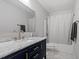 Stylish bathroom with a navy blue vanity, marble countertop, elegant gold fixtures, and a shower at 1304 Drew St, Durham, NC 27701