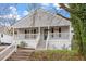 Inviting home featuring a covered front porch, grey siding, and well-maintained landscaping at 1304 Drew St, Durham, NC 27701