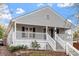 Charming home featuring gray siding, black shutters, a welcoming porch, and well-maintained landscaping at 1304 Drew St, Durham, NC 27701