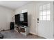 Cozy living room featuring a large flat screen TV, a white door, and carpeted flooring at 1304 Drew St, Durham, NC 27701