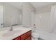 Bright bathroom featuring a shower and tub combo with white shower curtain and a cherry wood vanity at 131 Woodglen Dr, Clayton, NC 27527