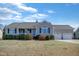 Charming single-story home featuring a two-car garage, porch, and a well-maintained front yard with landscaped bushes at 131 Woodglen Dr, Clayton, NC 27527