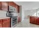 Kitchen featuring wood cabinets, laminate countertops, tile floors and stainless steel appliances, adjacent to a dining area at 131 Woodglen Dr, Clayton, NC 27527