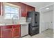 Practical kitchen with stainless steel appliances, including a dishwasher and refrigerator, and traditional-style cherry wood cabinets at 131 Woodglen Dr, Clayton, NC 27527