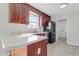 Functional kitchen featuring cherry wood cabinets, laminate countertops, and black appliances, including a refrigerator and dishwasher at 131 Woodglen Dr, Clayton, NC 27527