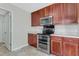 View of the kitchen area showcases stainless steel appliances and traditional wood cabinets against a light, neutral-colored wall at 131 Woodglen Dr, Clayton, NC 27527