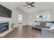 Bright living room features a fireplace, a gray sofa, and a view into an adjacent room and the front yard at 131 Woodglen Dr, Clayton, NC 27527