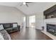 Spacious living room with dark wood floors, vaulted ceiling, fireplace, and a view into an adjacent dining area at 131 Woodglen Dr, Clayton, NC 27527