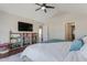 Comfortable main bedroom features TV, bookshelf, ceiling fan and access to ensuite bathroom at 131 Woodglen Dr, Clayton, NC 27527