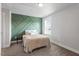 Bedroom with a unique green accent wall, plush carpet, and a well-lit window at 1312 Big Falls Dr, Wendell, NC 27591