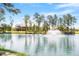 Scenic view of a community pond with a water fountain, clubhouse, and lush trees at 1312 Big Falls Dr, Wendell, NC 27591