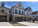 Stunning townhome showcasing brick and siding, a two-car garage, and manicured landscaping at 163 Periwinkle Pl, Clayton, NC 27527