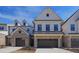 Beautiful townhome featuring a two-car garage and a combination of white siding and brick exterior at 163 Periwinkle Pl, Clayton, NC 27527