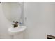 Pedestal sink and round mirror in a stylish half-bathroom at 163 Periwinkle Pl, Clayton, NC 27527