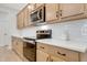 Modern kitchen includes white backsplash, stainless steel appliances, and wood cabinets at 163 Periwinkle Pl, Clayton, NC 27527