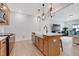 Bright kitchen features an island with a sink, modern pendant lights, and stainless steel appliances at 163 Periwinkle Pl, Clayton, NC 27527