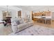 Open-concept living room with wood floors, a large sofa, and an adjacent dining area and kitchen at 163 Periwinkle Pl, Clayton, NC 27527