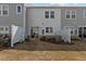 Backyard view showcasing townhouse exteriors with sliding glass doors, AC units, and small gardens at 175 Norwell Ln, Pittsboro, NC 27312