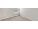 Neutral carpeted bedroom featuring a window with blinds providing natural light and a minimalist design at 176 Starlight St, Sanford, NC 27330