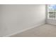 Neutral carpeted bedroom featuring a window with blinds providing natural light and a minimalist design at 176 Starlight St, Sanford, NC 27330