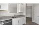 Bright kitchen features stainless steel dishwasher, gray countertops, and wood floors at 176 Starlight St, Sanford, NC 27330
