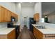 Bright kitchen with wood cabinets, black appliances, and hardwood floors at 1930 Maple Sugar Ln, Fuquay Varina, NC 27526