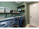 This laundry room has a modern washer and dryer with plenty of shelf space at 1930 Maple Sugar Ln, Fuquay Varina, NC 27526
