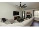 Spacious living room featuring a fireplace, dark wood floors, and a large ceiling fan at 1930 Maple Sugar Ln, Fuquay Varina, NC 27526