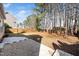 Large backyard with a wooden fence, patio and a line of mature trees at 209 Tullich Way, Holly Springs, NC 27540