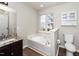 Bathroom featuring a vanity, a soaking tub, and a window for natural light at 209 Tullich Way, Holly Springs, NC 27540