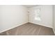 Bedroom featuring neutral carpet, white walls, and a large window at 209 Tullich Way, Holly Springs, NC 27540