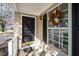 Inviting front porch featuring a dark front door with wreath, stylish exterior lighting, and a well-maintained entrance at 209 Tullich Way, Holly Springs, NC 27540