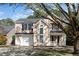 Charming two-story home features a manicured lawn, attached garage, and a welcoming front porch with decorative wreath at 209 Tullich Way, Holly Springs, NC 27540