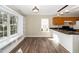Bright kitchen nook features a large window, wooden cabinets, and a breakfast bar with granite countertops at 209 Tullich Way, Holly Springs, NC 27540