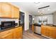 Updated kitchen showcasing light wood cabinets, stainless steel dishwasher, granite counters, and modern wood-look flooring at 209 Tullich Way, Holly Springs, NC 27540