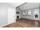 Living room features a fireplace with a white mantle, large windows providing natural light, vaulted ceiling, and a glass door at 209 Tullich Way, Holly Springs, NC 27540