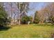 Spacious backyard featuring lush lawn, mature trees, and a shed at 212 W University Dr, Chapel Hill, NC 27516