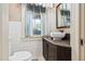 Small bathroom with classic white tiles, decorative vanity, and blue striped window treatment at 212 W University Dr, Chapel Hill, NC 27516