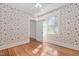 Bedroom with hardwood floors, floral wallpaper, and large windows for natural light at 212 W University Dr, Chapel Hill, NC 27516