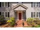 A charming front porch with brick steps, black iron railings, and planters at 212 W University Dr, Chapel Hill, NC 27516