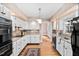 Charming kitchen features white cabinetry, granite countertops, and stainless steel appliances at 212 W University Dr, Chapel Hill, NC 27516
