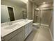 Bathroom featuring a double vanity with chrome fixtures, a glass shower and white porcelain toilet at 219 Adobe Pl, Cary, NC 27519