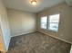 Bright bedroom featuring neutral walls, plush carpet, and ample natural light from double windows at 219 Adobe Pl, Cary, NC 27519