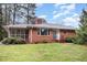 Cozy brick home featuring a screened in porch and well-maintained front yard at 2246 Hillandale Rd, Durham, NC 27705